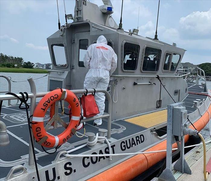 Servpro employee dressed in white Servpro tyvek on US Coast Guard Ship